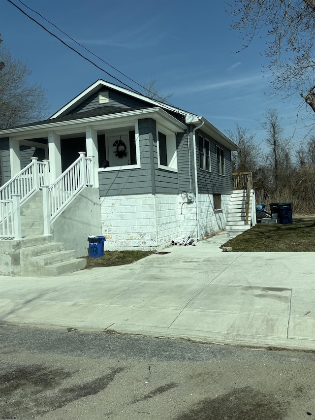 view of side of property with stairs and a porch