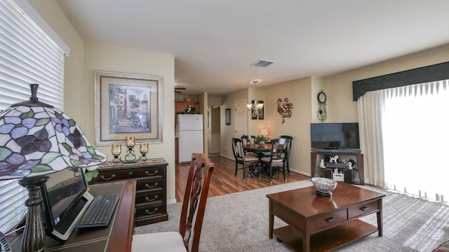 living area featuring baseboards, visible vents, and wood finished floors