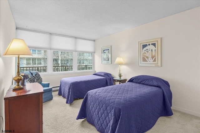 bedroom with carpet floors, a baseboard heating unit, a textured ceiling, and baseboards