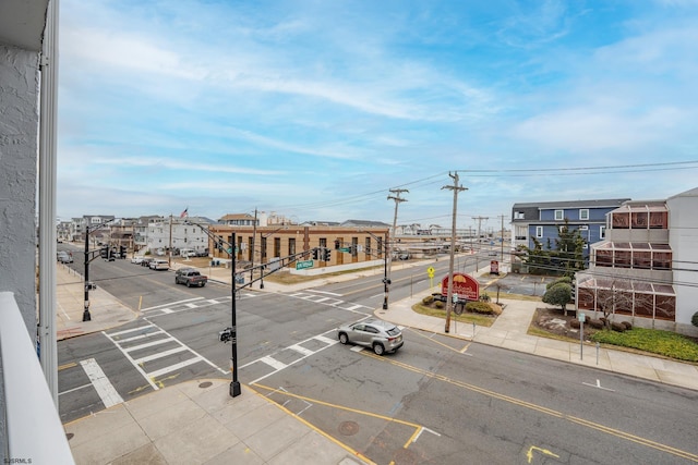 view of road with sidewalks, street lighting, and curbs