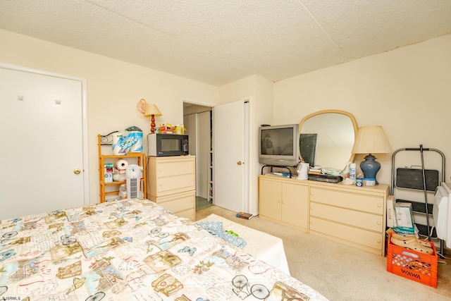 bedroom with light carpet and a textured ceiling