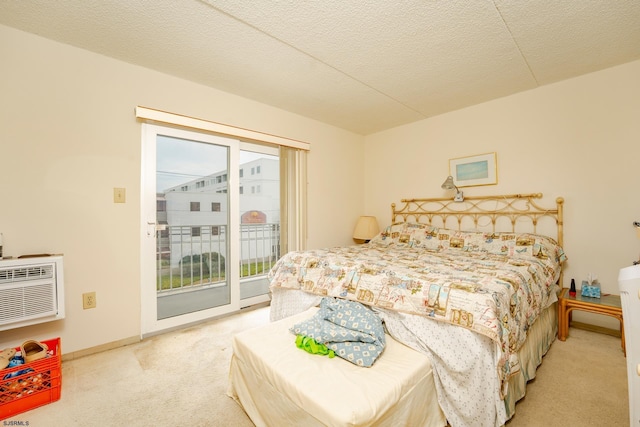 bedroom featuring a textured ceiling, carpet flooring, baseboards, access to exterior, and a wall mounted AC