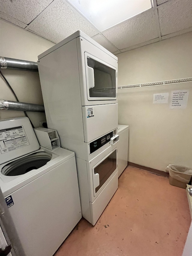 laundry area featuring stacked washer and dryer, washing machine and dryer, laundry area, and baseboards