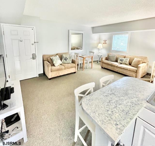 carpeted living room featuring a textured ceiling