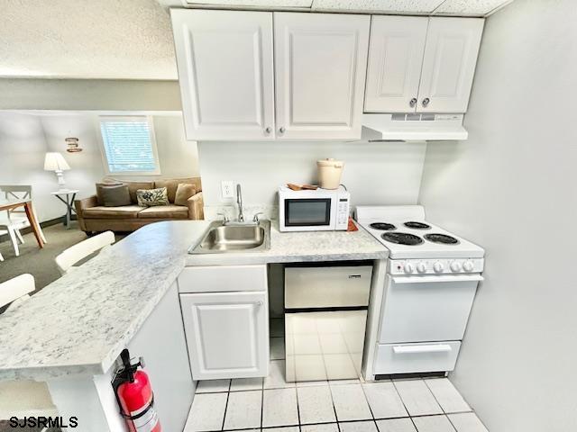 kitchen with white appliances, a sink, white cabinets, and under cabinet range hood