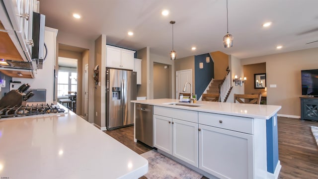 kitchen featuring a kitchen island with sink, recessed lighting, a sink, light countertops, and appliances with stainless steel finishes