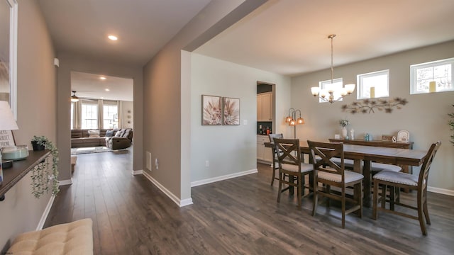 dining space with ceiling fan with notable chandelier, dark wood-type flooring, recessed lighting, and baseboards