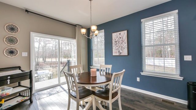 dining area with baseboards, dark wood-style flooring, visible vents, and an inviting chandelier