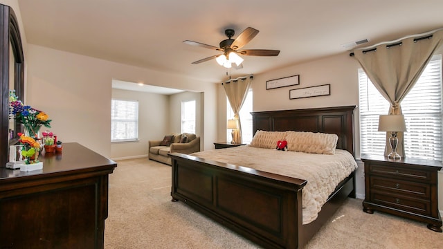 bedroom featuring baseboards, ceiling fan, visible vents, and light colored carpet