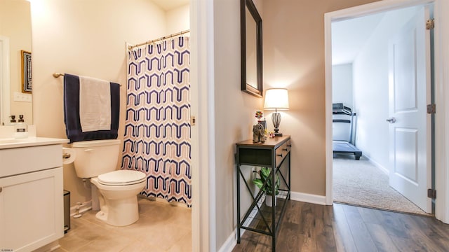 bathroom with toilet, a shower with shower curtain, wood finished floors, vanity, and baseboards