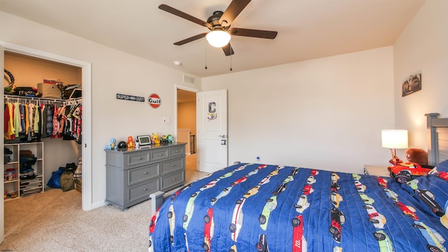 bedroom with visible vents, a ceiling fan, light colored carpet, a spacious closet, and a closet