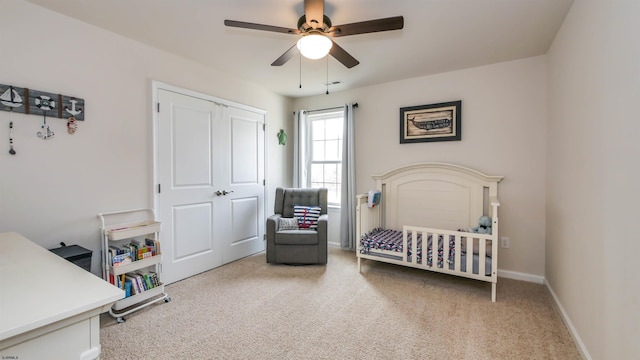 carpeted bedroom with ceiling fan, visible vents, baseboards, a closet, and a nursery area