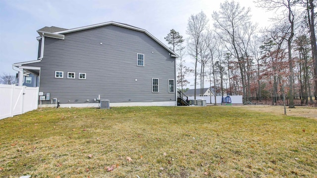 view of home's exterior featuring a yard, a fenced backyard, and central air condition unit