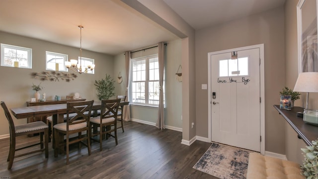 entryway featuring dark wood-style flooring, baseboards, and an inviting chandelier