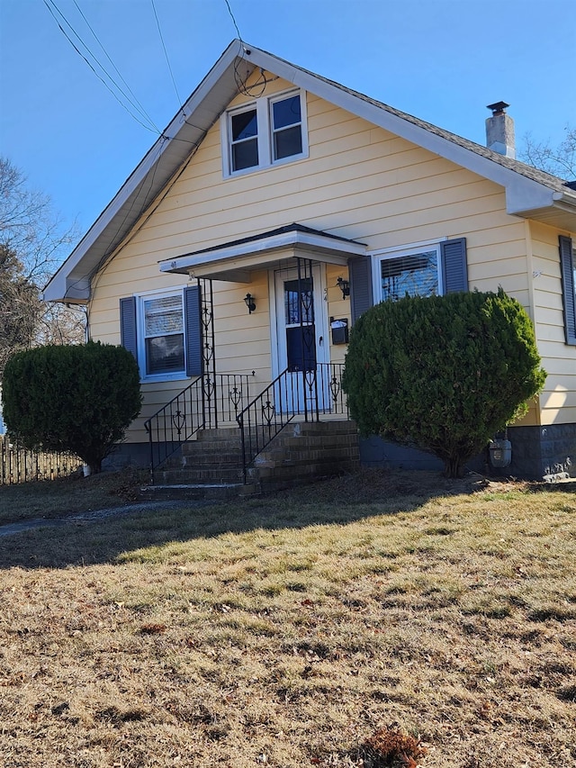 bungalow-style home with a front yard