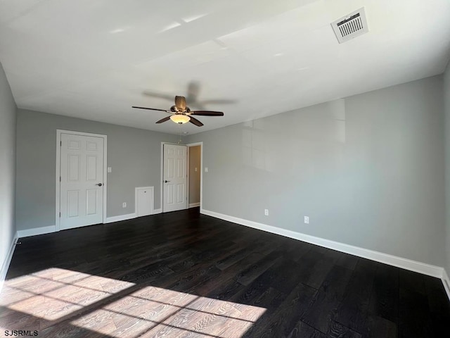 unfurnished room featuring baseboards, visible vents, ceiling fan, and dark wood-style flooring