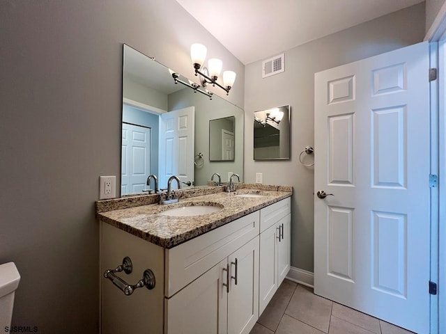 bathroom featuring double vanity, tile patterned flooring, visible vents, and a sink