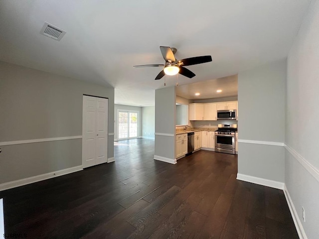 kitchen featuring dark wood-type flooring, visible vents, baseboards, open floor plan, and appliances with stainless steel finishes