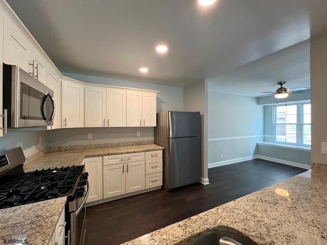 kitchen featuring white cabinets, light stone countertops, baseboards, and stainless steel appliances