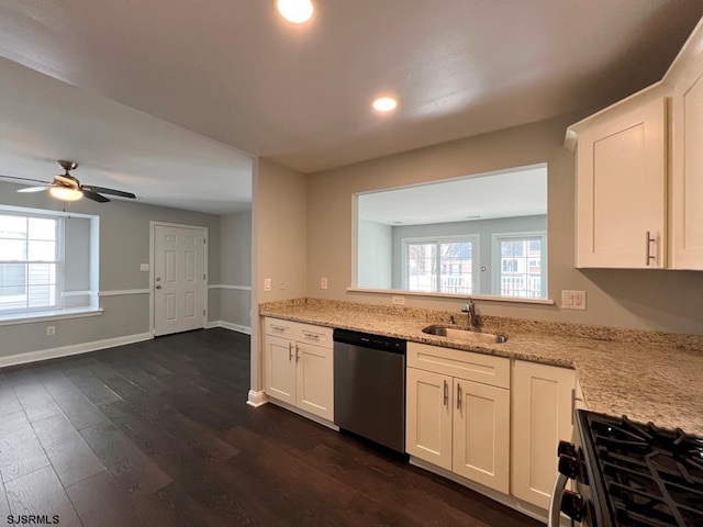 kitchen featuring light stone counters, stainless steel appliances, dark wood-style flooring, a sink, and white cabinetry