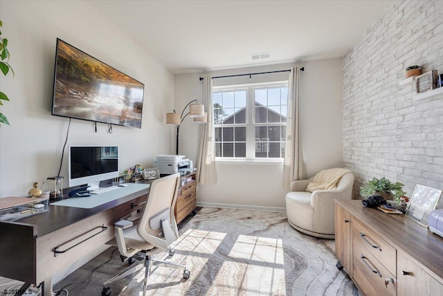 office featuring brick wall, visible vents, and baseboards