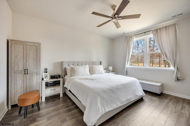 bedroom with visible vents, dark wood finished floors, baseboards, and ceiling fan