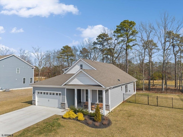 view of front of property with a porch, a front yard, fence, and a garage