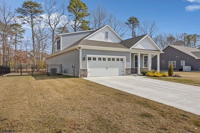 view of front of home with an attached garage, fence, stone siding, driveway, and a front lawn