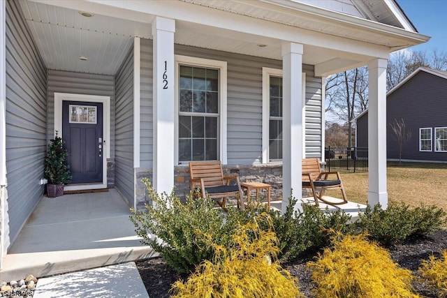 property entrance featuring covered porch and stone siding