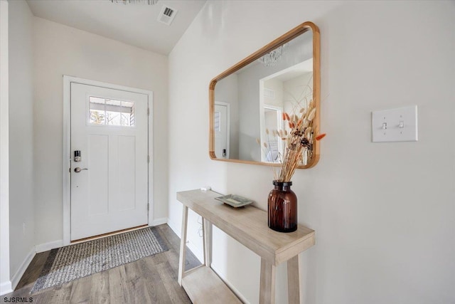 entryway featuring visible vents, baseboards, and wood finished floors