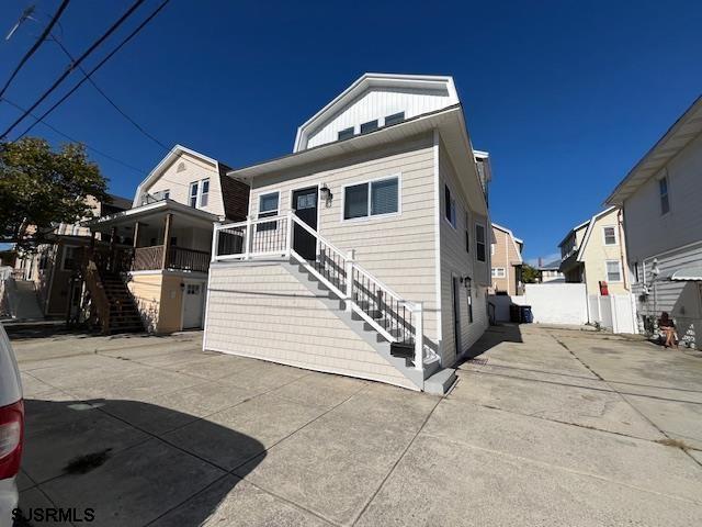 view of front of house with a patio area, stairs, and board and batten siding