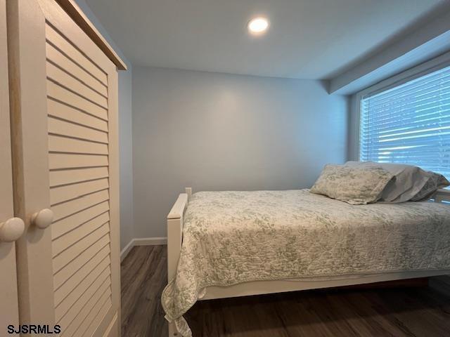 bedroom featuring dark wood-style floors and baseboards