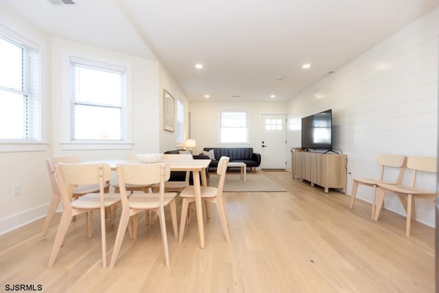 dining room featuring baseboards, light wood finished floors, and recessed lighting