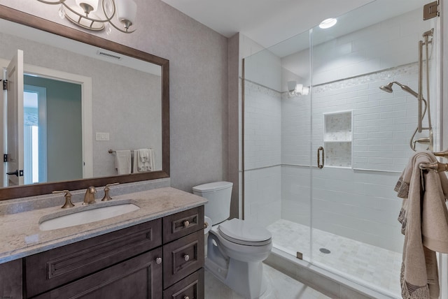 bathroom with toilet, a stall shower, visible vents, and vanity