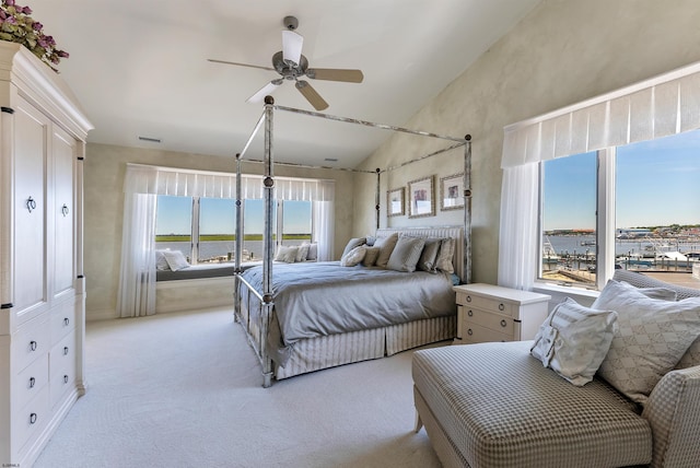 bedroom featuring a ceiling fan, lofted ceiling, light colored carpet, and visible vents