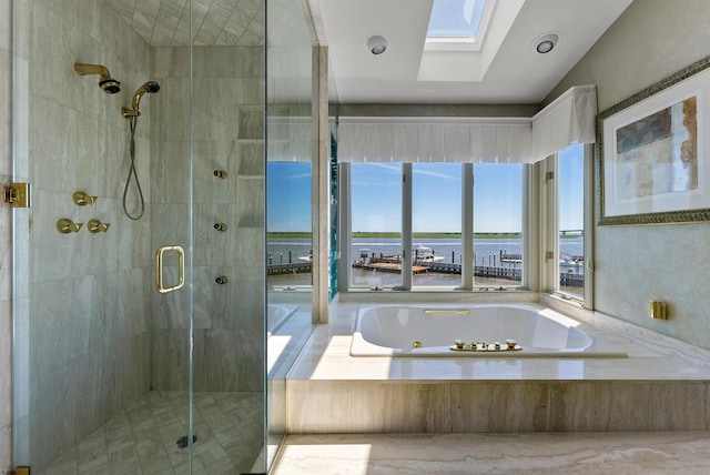 full bathroom featuring a jetted tub, a skylight, a water view, and a stall shower