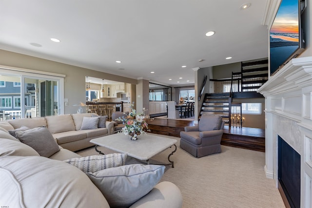 living room with a healthy amount of sunlight, recessed lighting, stairs, and a premium fireplace