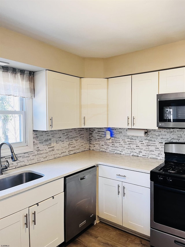 kitchen featuring tasteful backsplash, stainless steel appliances, a sink, and light countertops