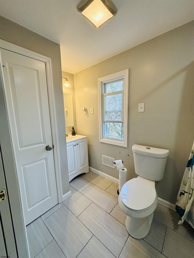 bathroom with toilet, baseboards, visible vents, and vanity