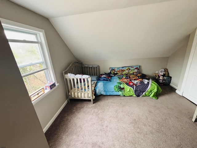 carpeted bedroom featuring lofted ceiling and baseboards