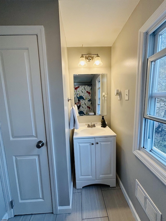 bathroom with visible vents, vanity, and baseboards