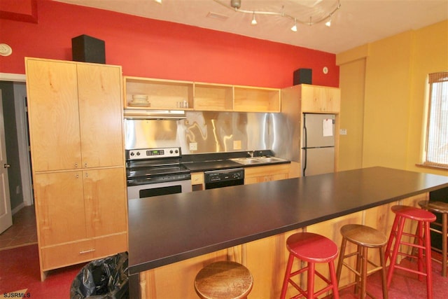 kitchen with black dishwasher, dark countertops, freestanding refrigerator, and stainless steel range with electric cooktop