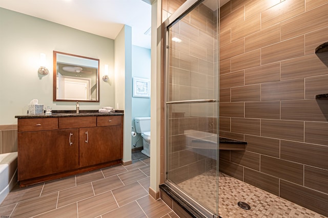 bathroom featuring toilet, a stall shower, and vanity