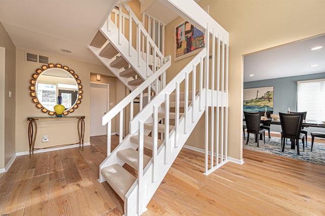 stairs featuring baseboards, visible vents, wood finished floors, and recessed lighting