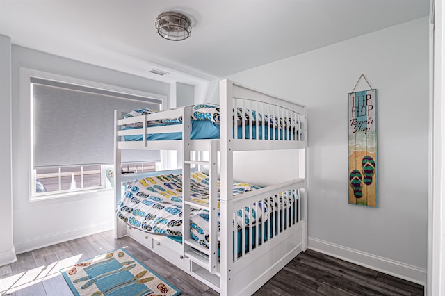 bedroom featuring wood finished floors, visible vents, and baseboards