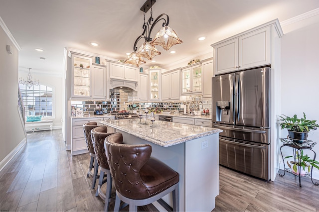 kitchen with tasteful backsplash, appliances with stainless steel finishes, dark wood finished floors, and ornamental molding