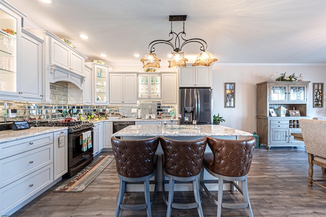 kitchen with stainless steel fridge, ornamental molding, a center island, backsplash, and gas stove