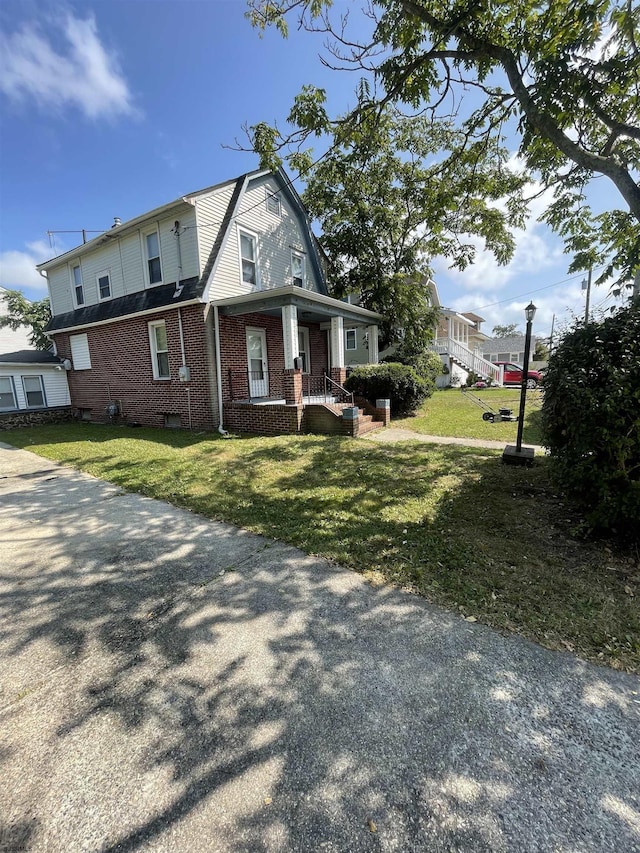 view of property exterior with brick siding, a yard, and a gambrel roof