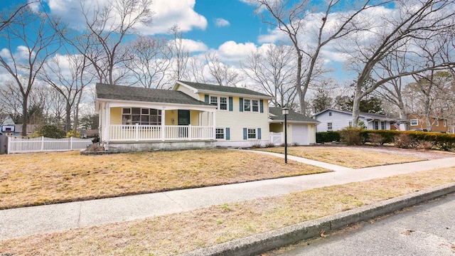 tri-level home featuring a garage, driveway, a porch, fence, and a front lawn