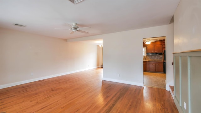 unfurnished room with light wood finished floors, ceiling fan, visible vents, and baseboards